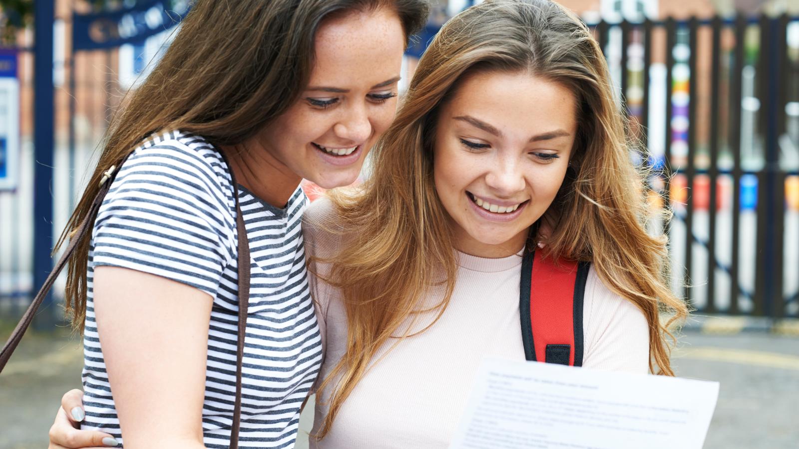 Two girls looking at page containing exam results